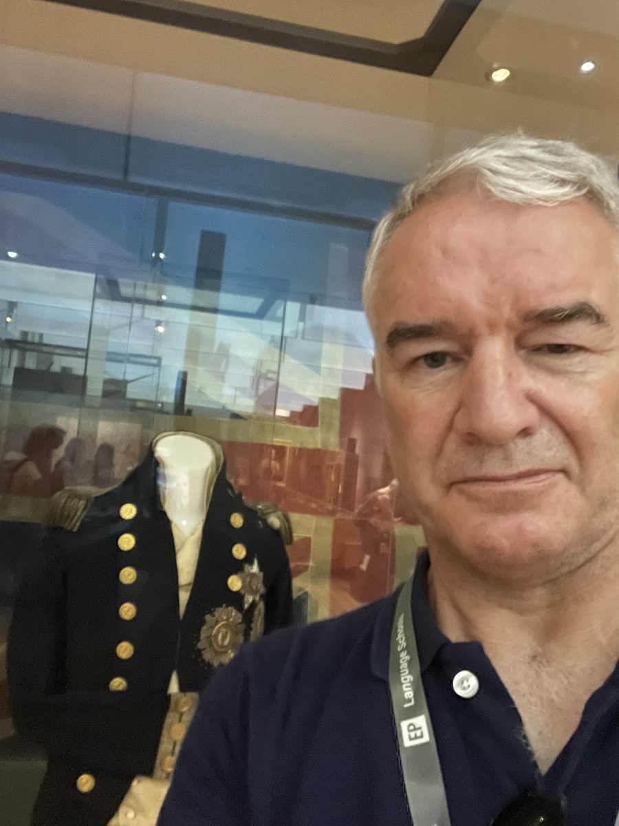 Eddie Barber beside Admiral Lord Nelson's naval uniform on display